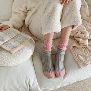 Close-up of grey and pink thick wool knit socks with ribbed texture for winter warmth
