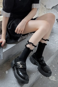 Détails des Mary Janes en cuir verni noir avec chaussettes à froufrous et nœuds
