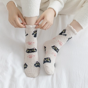 Detailed texture of thick cream coral fleece socks featuring cute cat jacquard patterns