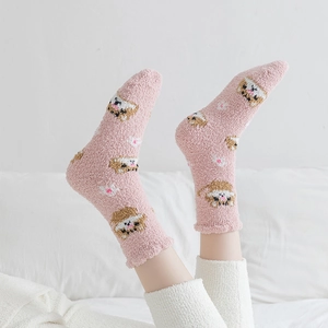 Close-up of pink coral fleece socks with cute cartoon cat patterns for winter warmth