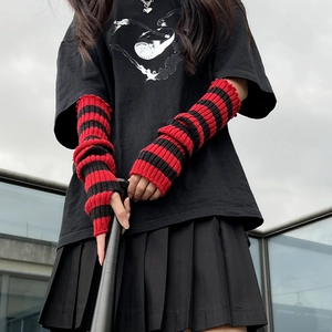 Detail of red and black striped knitted arm warmer sleeves with thumb holes for goth style