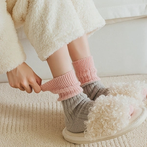 Detailed close-up of pink and grey wool socks showing thick texture and ribbing detail