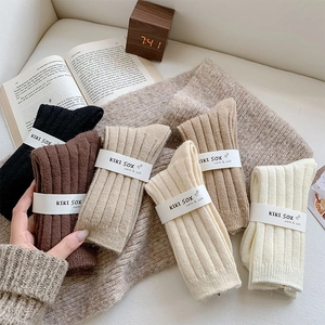 Close-up of thick ribbed wool blend socks in earthy tones with warm knit background