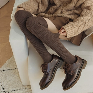 Close-up of brown over-the-knee wool socks featuring a vertical ribbed knit texture