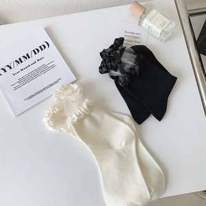 Vue détaillée des chaussettes en dentelle style JK avec nœuds en noir et blanc crème