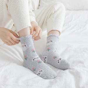 Fuzzy coral fleece thermal socks featuring cute cartoon sheep on soft gray fabric