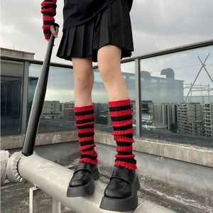 Detail of red and black striped knit leg warmers and fingerless gloves in punk style