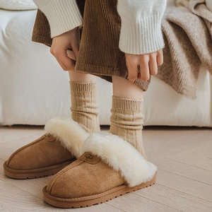 Close-up of brown suede slippers with white faux fur lining and plush inner texture