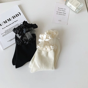 Détail des volants en dentelle et nœuds en satin sur les chaussettes en résille