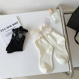 Détail de chaussettes mi-mollet style JK avec volants en organza et nœuds satin