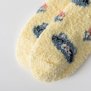 Close-up of soft yellow coral fleece thermal socks with blue and pink jacquard patterns