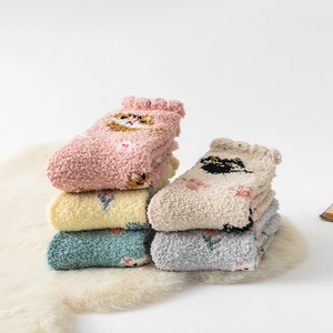 Close-up of thick coral fleece winter socks with cute cartoon cat patterns and soft texture