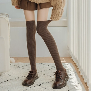 Detail of dark brown wool knee socks with vertical knit pattern and elastic ribbed cuff