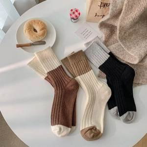 Detailed close-up of thick rib-knit texture on three color-block winter wool socks