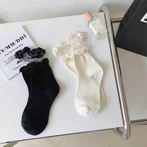 Détails de dentelle à volants et nœuds sur chaussettes hautes blanches et noires