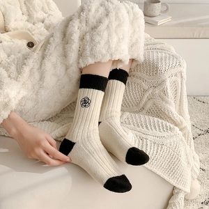Winter wool socks for women with camellia embroidery in a black and white color block style