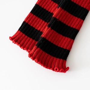 Close-up of red and black striped knit leg warmers with ribbed cuff details