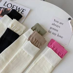 Macro shot of assorted multi-color ribbed calf socks arranged on a white table top