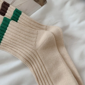 Detailopname van geribbelde katoenen sokken met groene en bruine gestreepte boorden