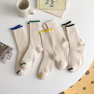 Close-up of five pairs of ribbed knit mid-calf socks with colorful edge detailing