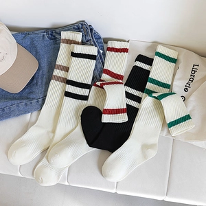 Detail of striped knee-high cotton socks in white and black casual collegiate style