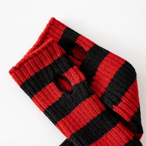 Close-up of red and black striped knit arm warmers with thumb holes and ribbed edges