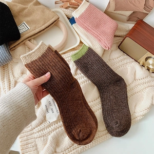 Close-up of thick knitted wool socks in brown color with a branded tag and warm texture