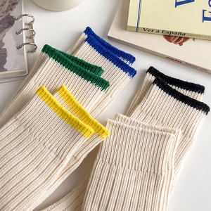 Detailed close-up of ribbed knit crew socks with colorful striped cuffs in a cozy aesthetic