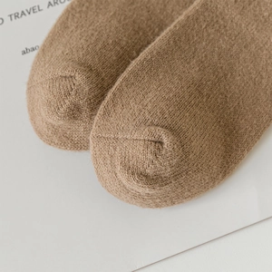 Close-up of thick knitted wool sock toes with fine stitching in a warm brown color