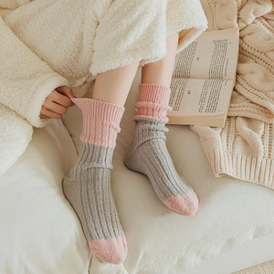 Thick wool socks in grey and pink patchwork knit for warm winter home wear and comfort