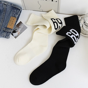 Détail de chaussettes en maille à côtes verticales et jacquard numéro 69 sur blanc