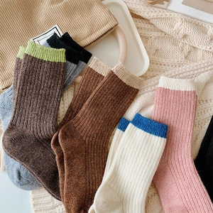 Detail of ribbed knit texture on thick winter wool crew socks in various warm colors