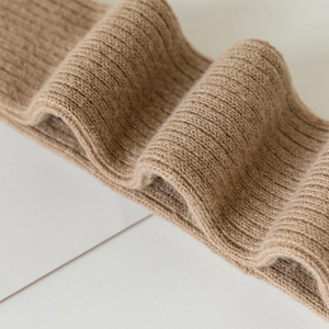 Macro detail of camel wool knit texture and ribbed pattern on high-quality warm over-knee socks
