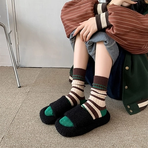 Zwarte pluizige platform slippers voor dames met groen-bruine gestreepte sokken