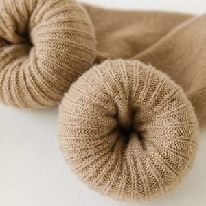 Macro shot of camel knit wool socks featuring thick ribbed texture and warm rolled cuffs