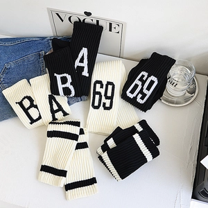 Détail de chaussettes hautes rayées noir et blanc avec motifs de lettres et de chiffres