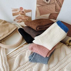 Detail of warm chunky knit socks in various colors on a cozy soft textured background