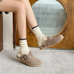 Detail of white ribbed crew socks paired with brown suede clogs and warm fleece lining