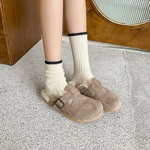 Detail of warm khaki suede clogs with thick cream rib-knitted socks for cozy winter style