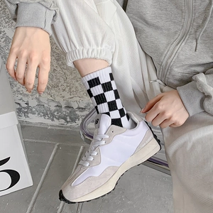 Side view of beige and grey suede sneakers featuring mesh texture on a model