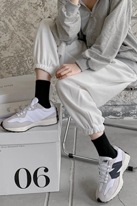 Close-up of checkerboard socks with thick white and grey sneakers in a street style look