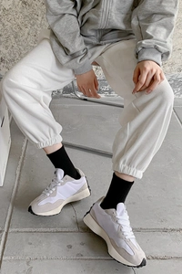 Detail of checkered crew socks paired with waffle knit pants and retro sport sneakers
