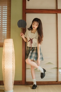 Close-up of JK school uniform with white lace socks and black leather loafers on tatami