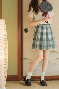 Close-up of JK school uniform pleated plaid skirt with white lace socks and leather shoes