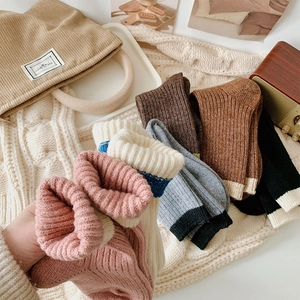 Detailed knit texture of thick wool ribbed socks in various autumn colors and soft tones