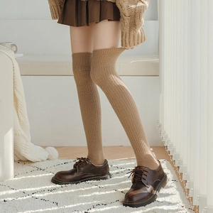 Brown wool rib-knit over-knee socks styled with retro leather shoes and a pleated skirt