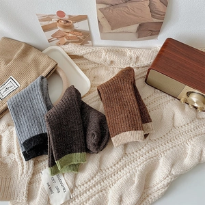 Close-up of thick ribbed wool socks in earth tones showing warm knitted texture and patterns
