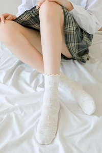 Détail macro de chaussettes blanches à fleurs texturées et bords à volants style JK