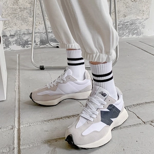 Detailed close-up of retro checkered sports socks paired with white sneakers on feet