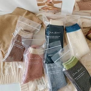 Detail of ribbed knit wool socks in various colors packed in clear individual bags